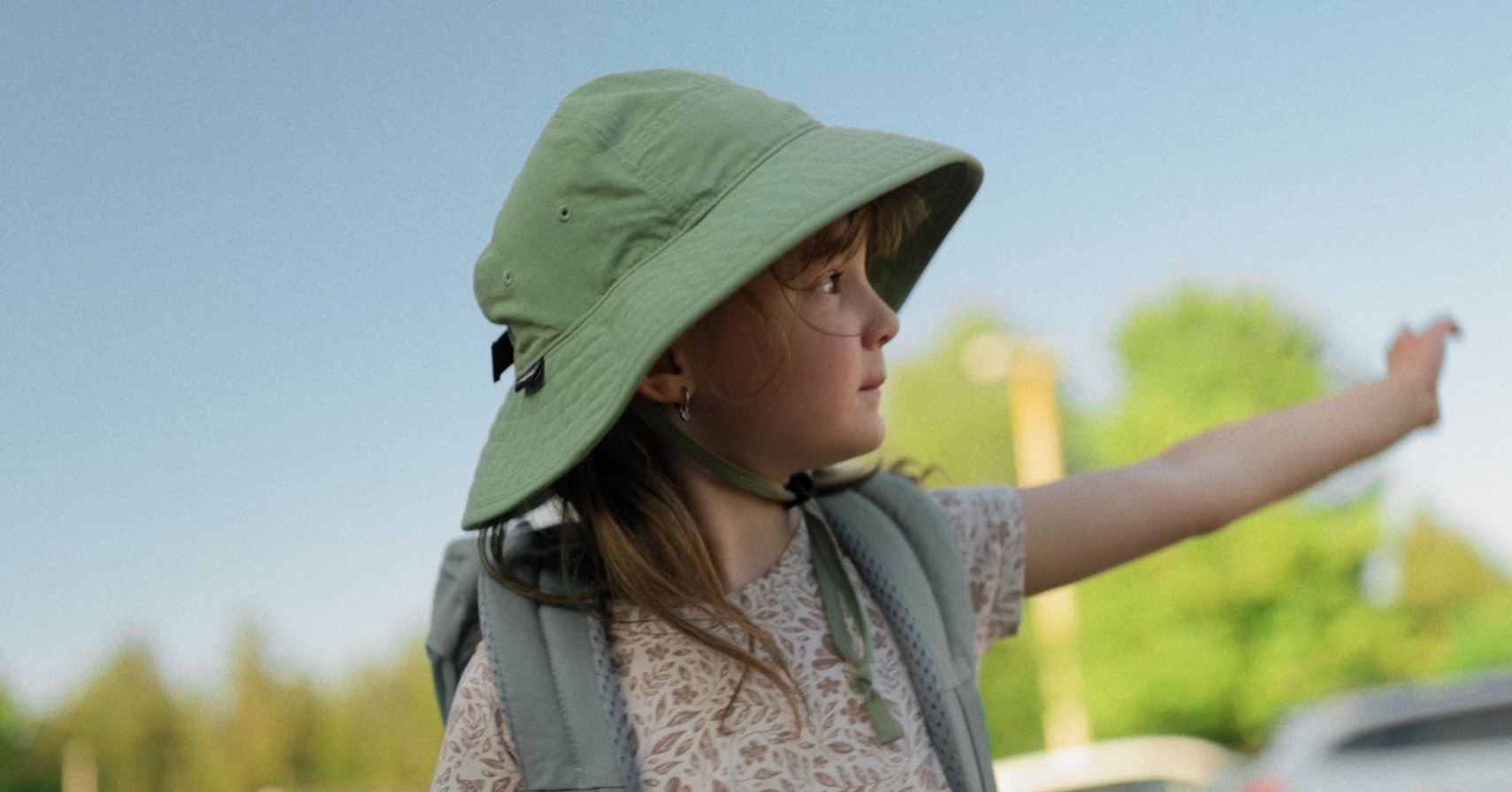 Child pointing to the trees on a sunny walk
